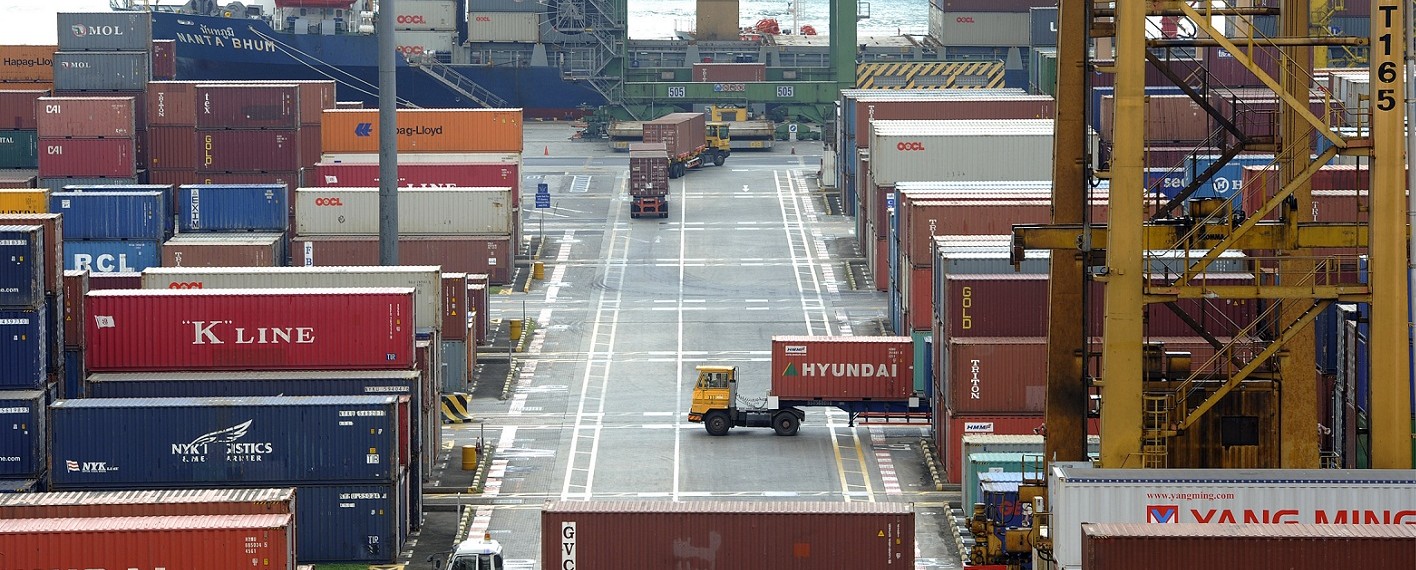 Trucks transport containers at the Keppel Container Terminal, operated by PSA International Pte Ltd., in Singapore, on Wednesday, Dec. 14, 2011. Singapore's exports unexpectedly rose in November as pharmaceutical sales countered weak demand for electronics amid a faltering global recovery. Photographer: Bryan van der Beek/Bloomberg